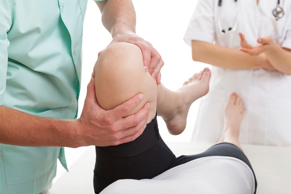 doctor examines knee joint pain
